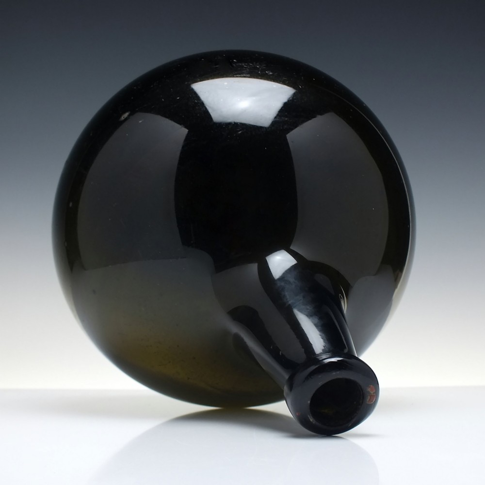 A large, dark green hand-blown antique glass wine bottle with a bulbous body and tapered neck. View III