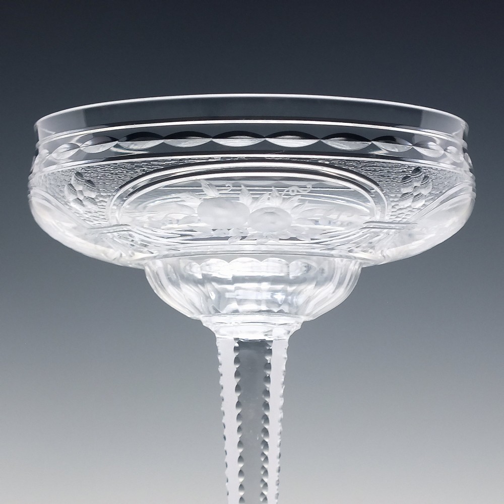 A set of six French Art Nouveau clear lead crystal champagne coupes with tall beaded stems and etched floral motifs on shallow bowls. View IV