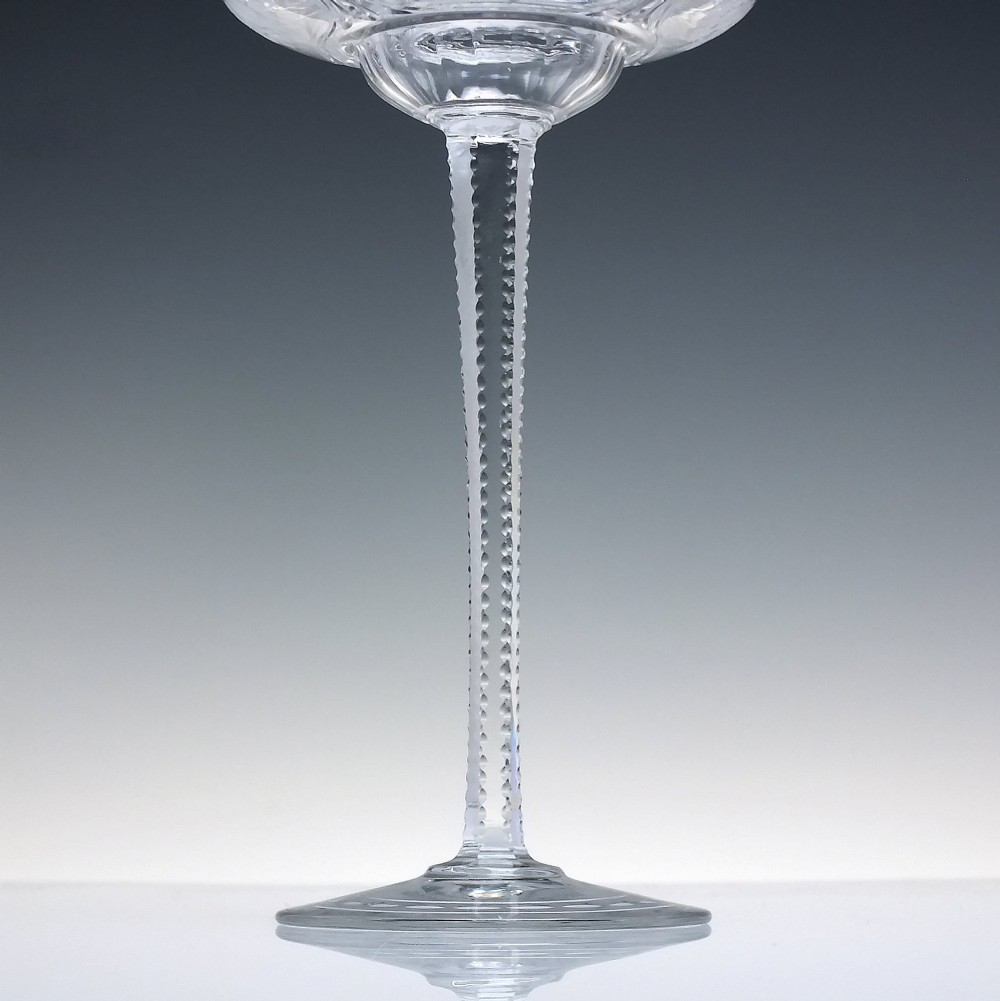 A set of six French Art Nouveau clear lead crystal champagne coupes with tall beaded stems and etched floral motifs on shallow bowls. View IX
