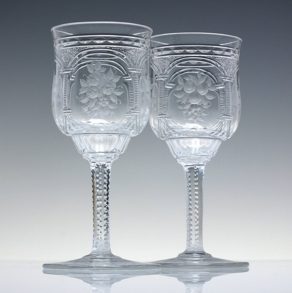 A set of six clear lead crystal dram glasses featuring acid-etched floral panels set within archways and faceted diamond-cut stems. View II