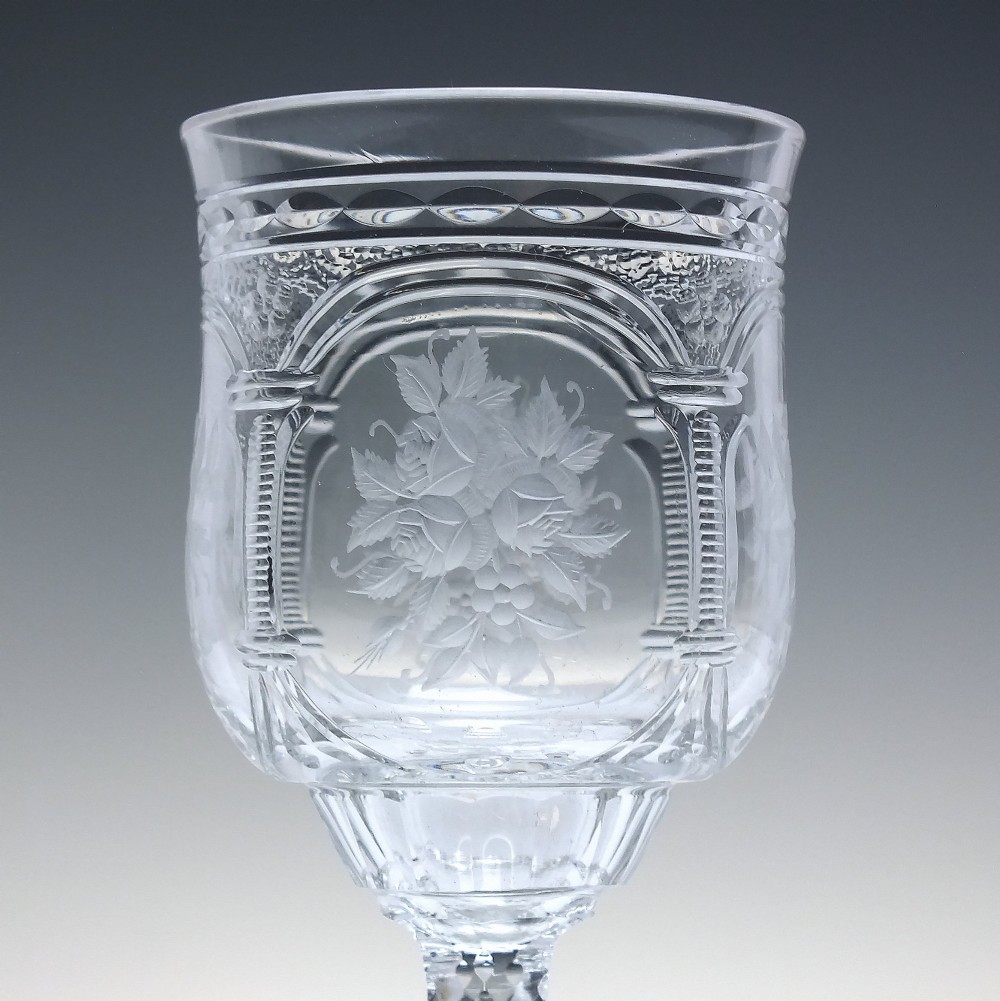 A set of six clear lead crystal dram glasses featuring acid-etched floral panels set within archways and faceted diamond-cut stems. View V