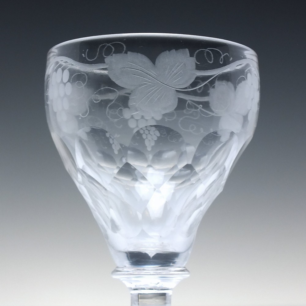 A set of six vintage clear glass port goblets featuring wheel-engraved grapevine motifs on pan-topped bowls with cut facet details. View V