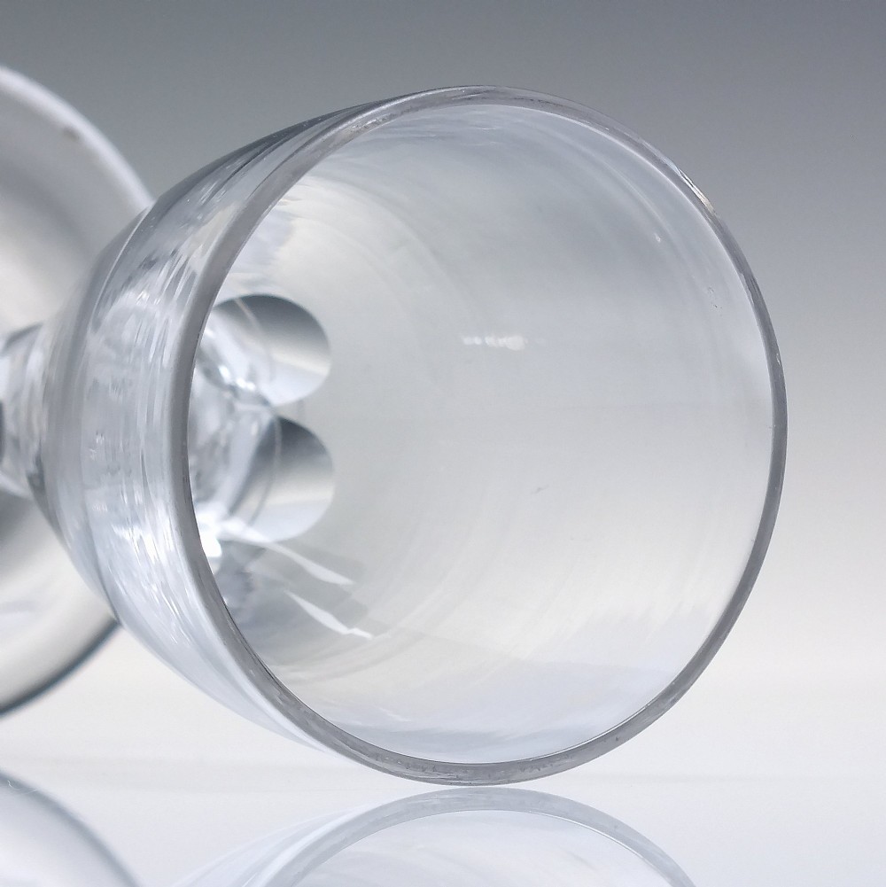 An 18th-century clear lead crystal dram glass with a rounded bowl and a diamond facet-cut stem resting on a circular base. View V