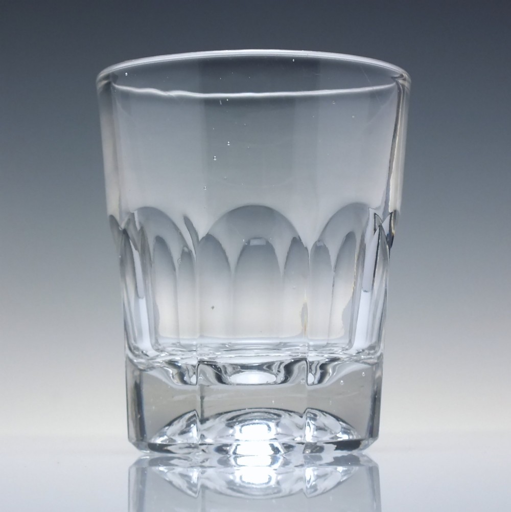 A clear mid-19th-century Victorian glass whisky tumbler featuring fluted panels around the lower body and a thick base.