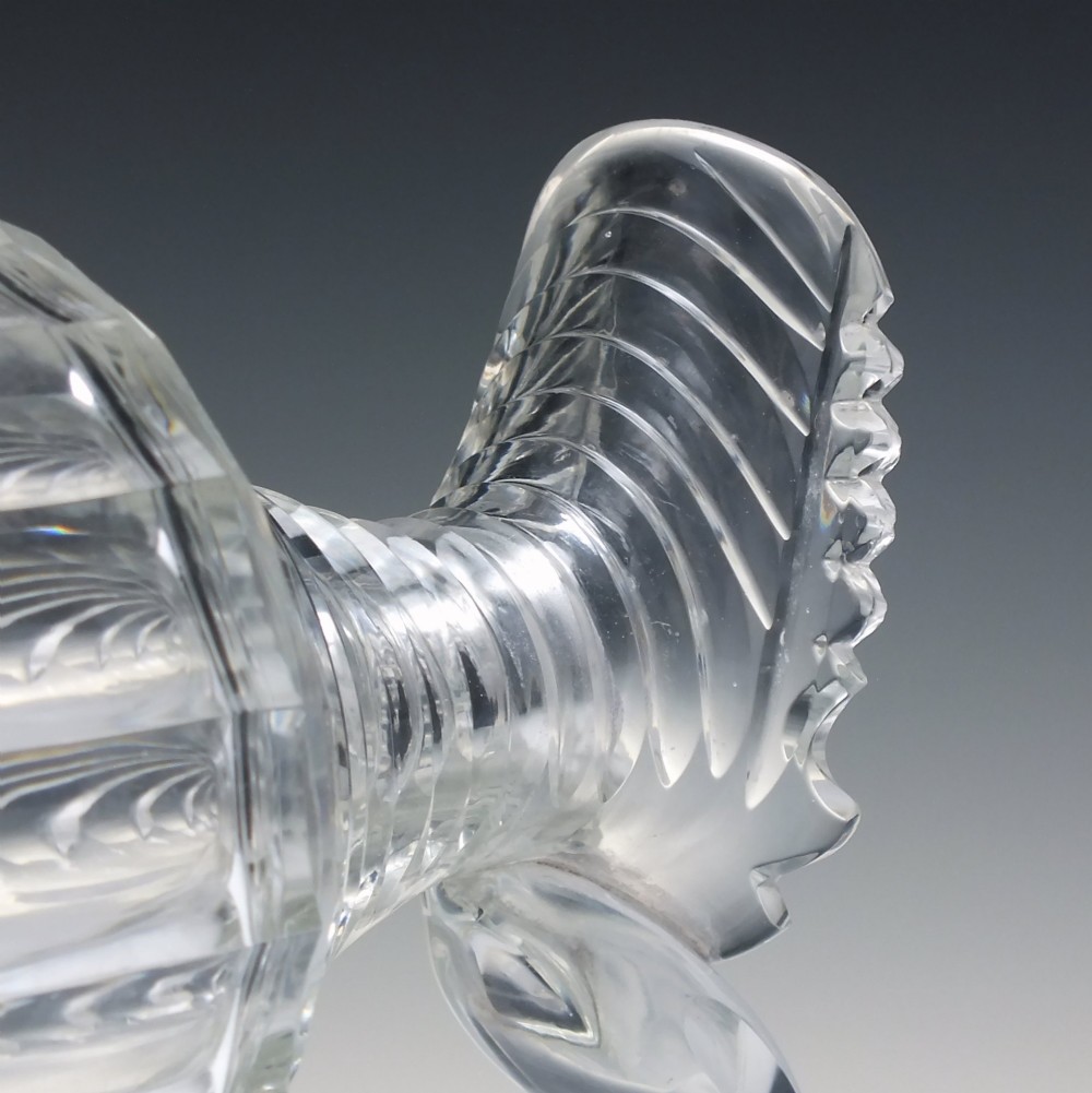 A clear Georgian Regency cut glass claret jug with a step-cut neck, panelled body, applied handle, and faceted stopper. View V