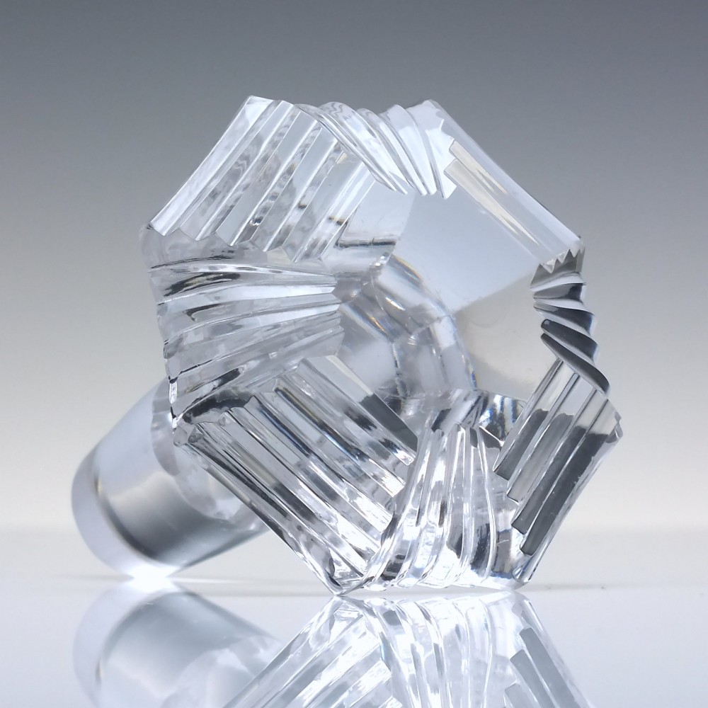 A clear Georgian Regency cut glass claret jug with a step-cut neck, panelled body, applied handle, and faceted stopper. View IX
