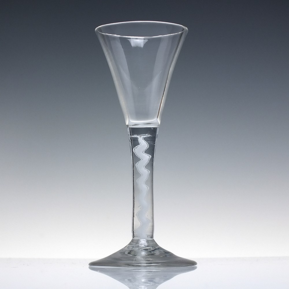 An 18th-century clear lead glass wine glass featuring a flared trumpet bowl, a central white opaque twist stem, and a circular conical foot. View II