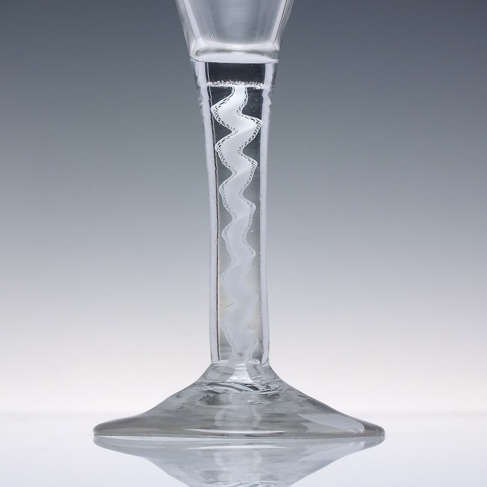 An 18th-century clear lead glass wine glass featuring a flared trumpet bowl, a central white opaque twist stem, and a circular conical foot. View III