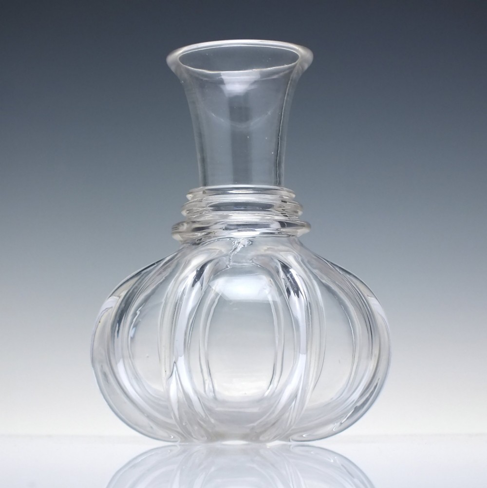 A clear glass wine carafe featuring a bulbous body with vertical pillar moulding, applied neck rings, and a flared rim.