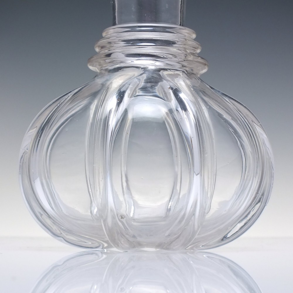 A clear glass wine carafe featuring a bulbous body with vertical pillar moulding, applied neck rings, and a flared rim. View V
