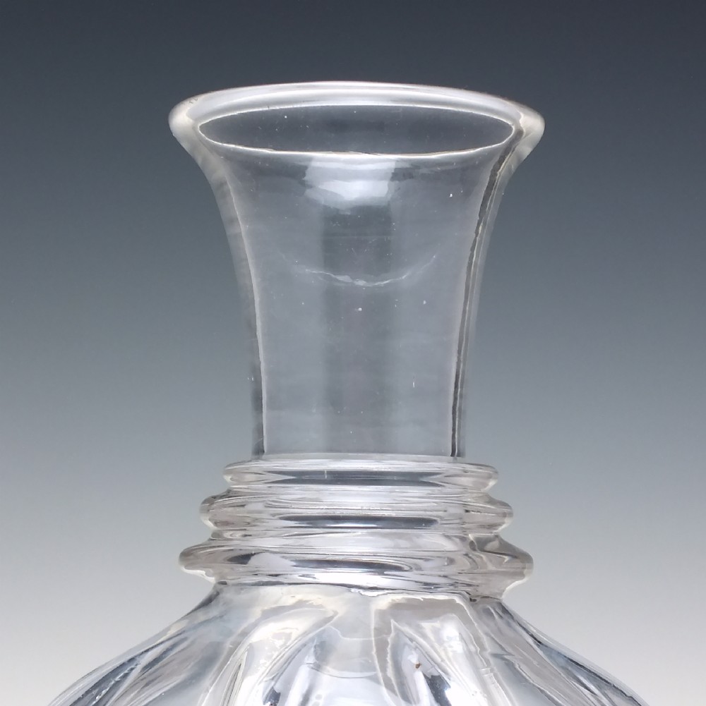 A clear glass wine carafe featuring a bulbous body with vertical pillar moulding, applied neck rings, and a flared rim. View VI
