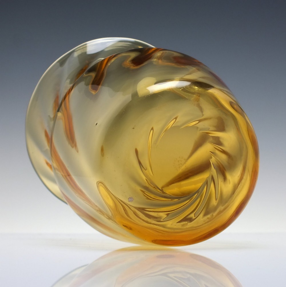 An amber crystal vase featuring a twisted optical swirl pattern and a flared rim. View IV