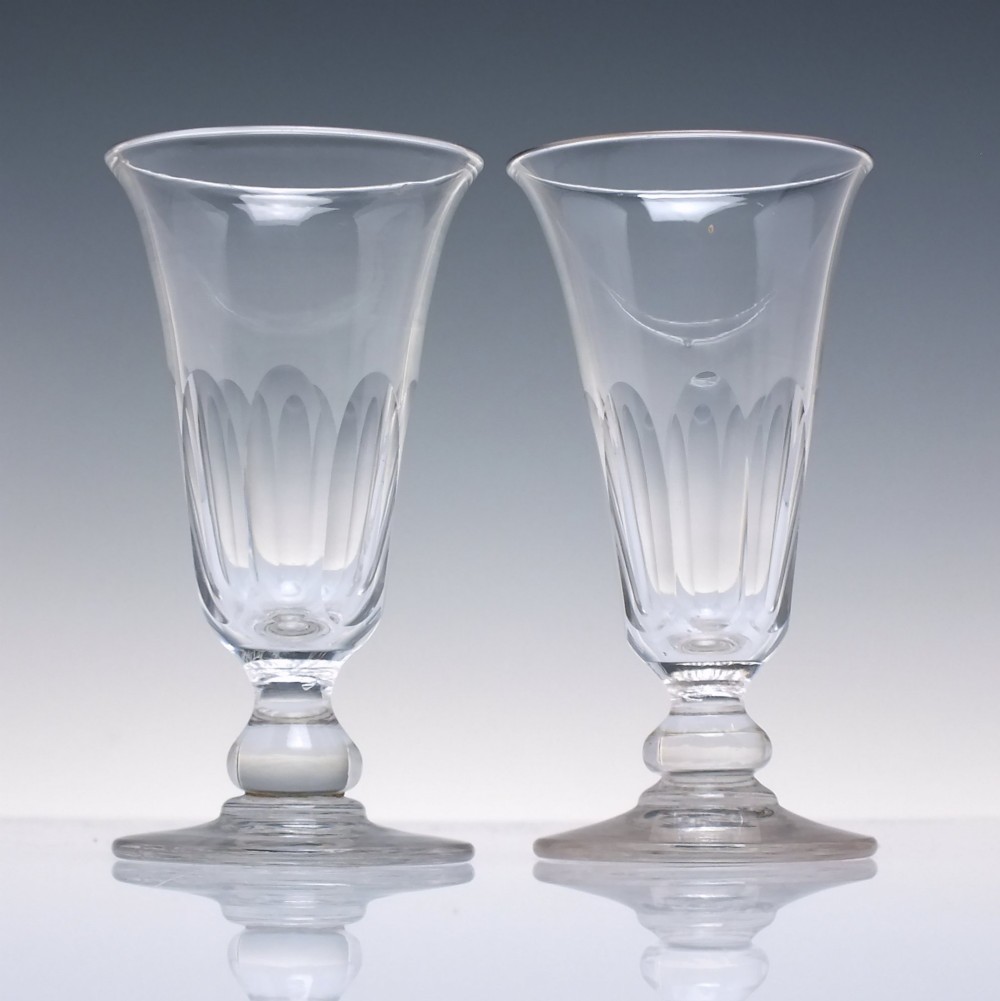 A pair of clear cut-glass Georgian jelly glasses featuring flared rims, panel-cut lower bowls, short knopped stems, and circular flat bases. View II