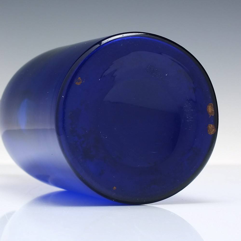 A dark cobalt blue Victorian hand-blown glass serving bottle featuring a tapered neck, double collar, and smooth cylindrical body. View V