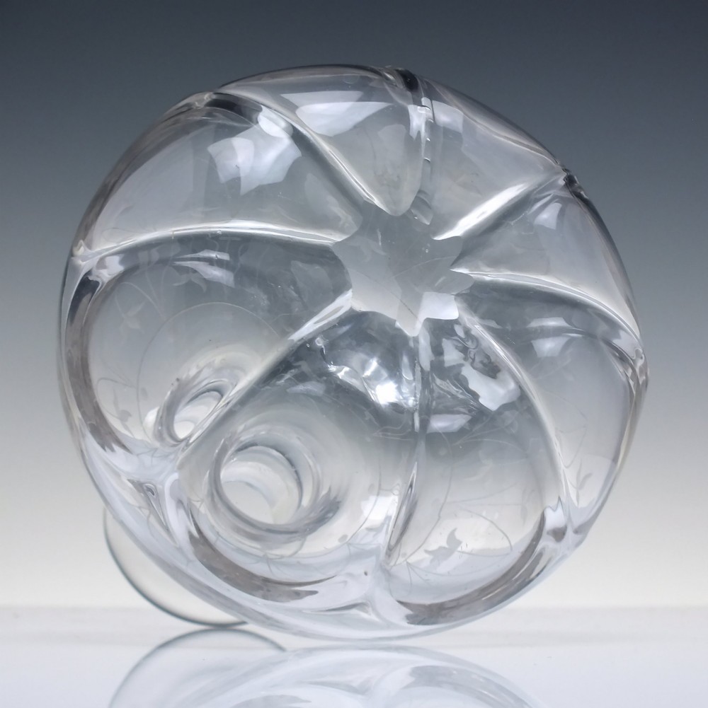 A mid-19th century clear glass wine carafe featuring an engraved foliate upper band and cut panel arches around the bulbous base. View III