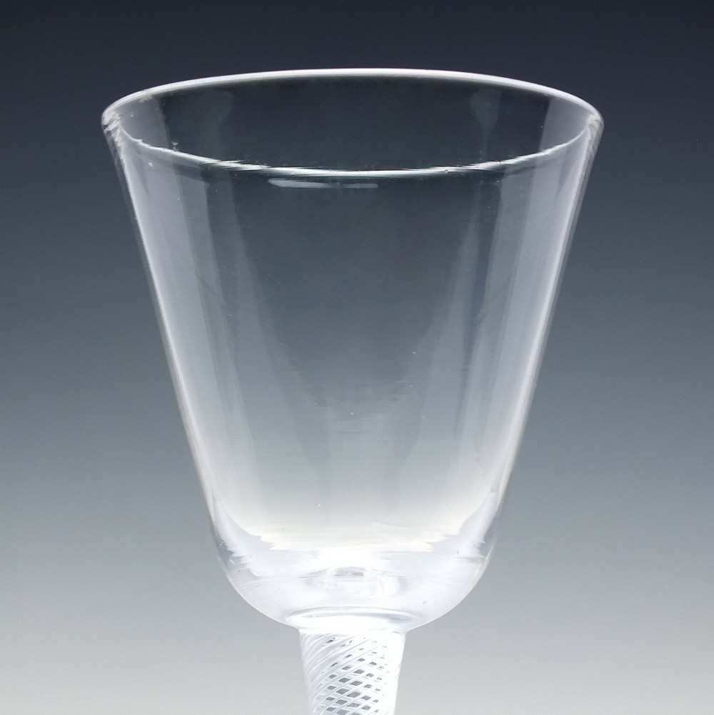 An 18th-century clear lead glass wine glass featuring a knopped air twist stem and a bell-shaped bowl supported by a conical foot. View IV