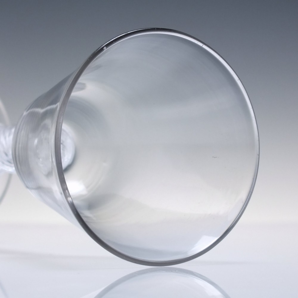 An 18th-century clear lead glass wine glass featuring a knopped air twist stem and a bell-shaped bowl supported by a conical foot. View V