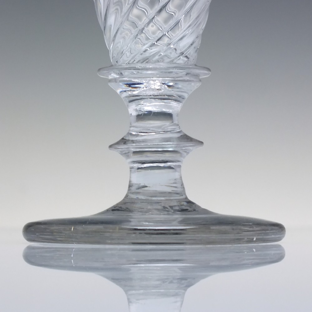 A clear Georgian lead glass ale goblet featuring half wrythen spiral moulding on the conical bowl and a knopped stem. View III