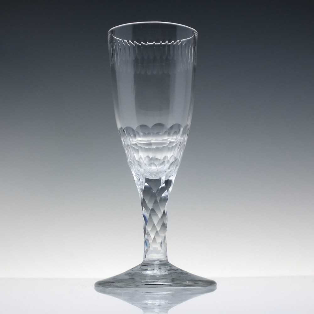 An 18th-century clear lead crystal ale glass featuring a faceted stem, a wide conical foot, and geometric cut decoration on the bowl. View II
