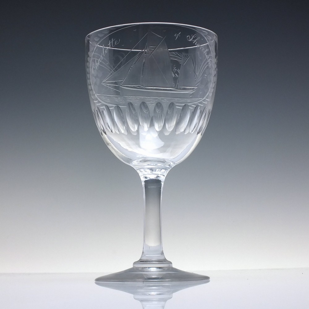 A pair of clear glass Victorian wine goblets featuring wheel-engraved sailing ships, inscriptions, and cut oval fluting around the lower bowls. View III