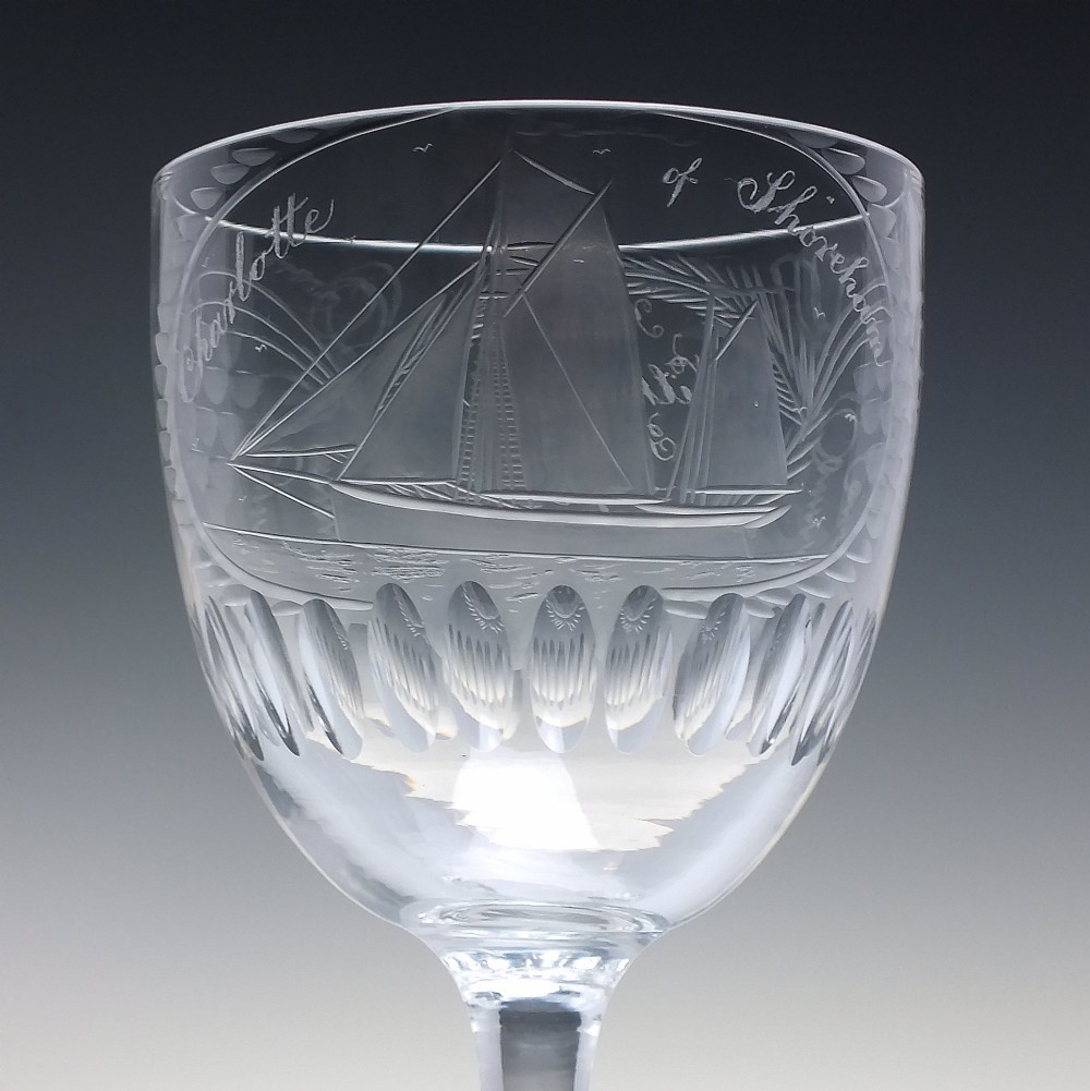 A pair of clear glass Victorian wine goblets featuring wheel-engraved sailing ships, inscriptions, and cut oval fluting around the lower bowls. View IV