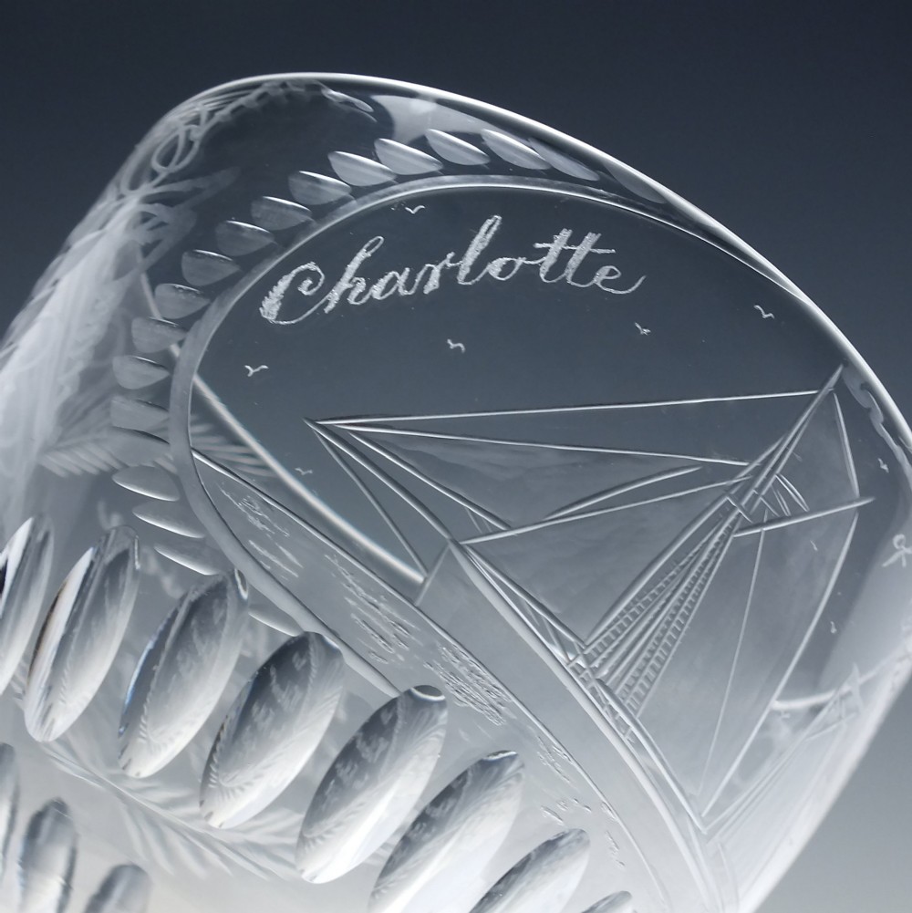 A pair of clear glass Victorian wine goblets featuring wheel-engraved sailing ships, inscriptions, and cut oval fluting around the lower bowls. View VI