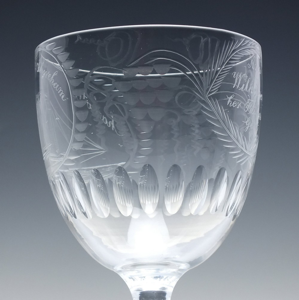 A pair of clear glass Victorian wine goblets featuring wheel-engraved sailing ships, inscriptions, and cut oval fluting around the lower bowls. View VIII