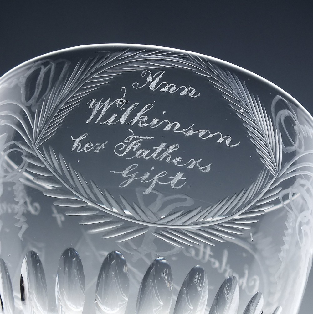 A pair of clear glass Victorian wine goblets featuring wheel-engraved sailing ships, inscriptions, and cut oval fluting around the lower bowls. View IX