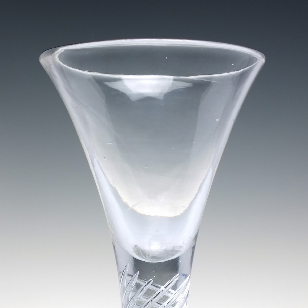 A clear Georgian dram glass featuring a flared trumpet bowl, a multi-spiral air twist stem, and a broad conical foot. View IV
