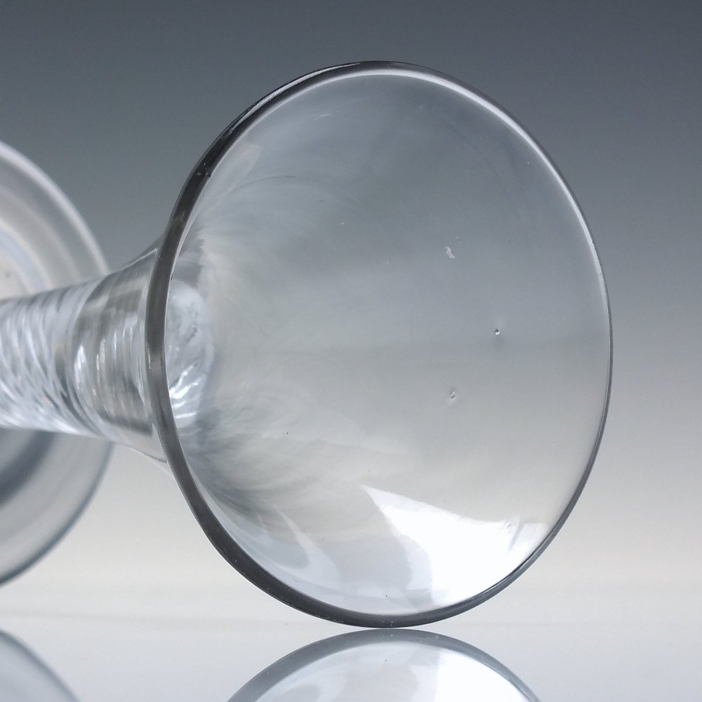 A clear Georgian dram glass featuring a flared trumpet bowl, a multi-spiral air twist stem, and a broad conical foot. View V