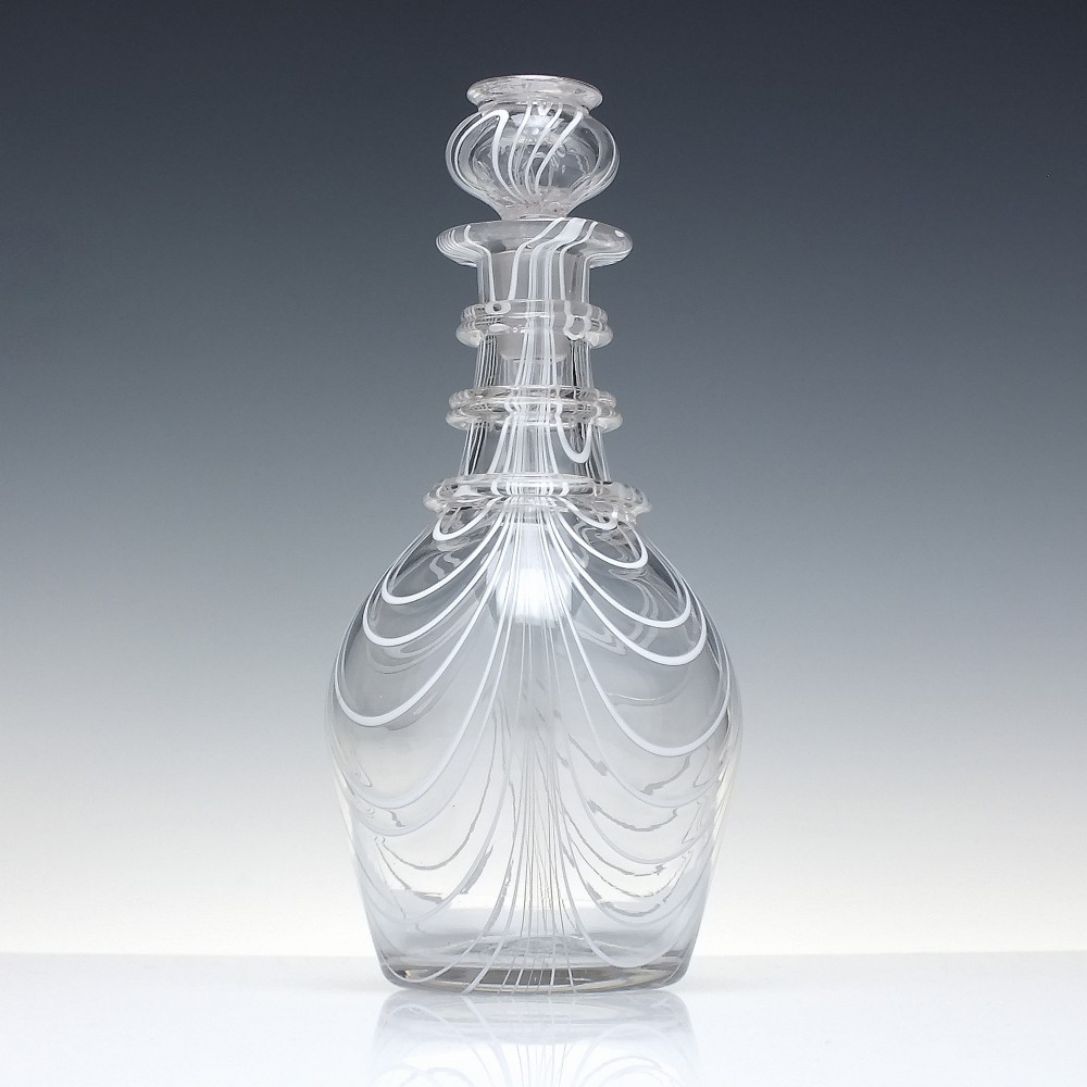 A clear lead glass Regency Prussian-shaped personal spirit decanter decorated with combed opaque white trailing and fitted with a matching glass stopper. View II