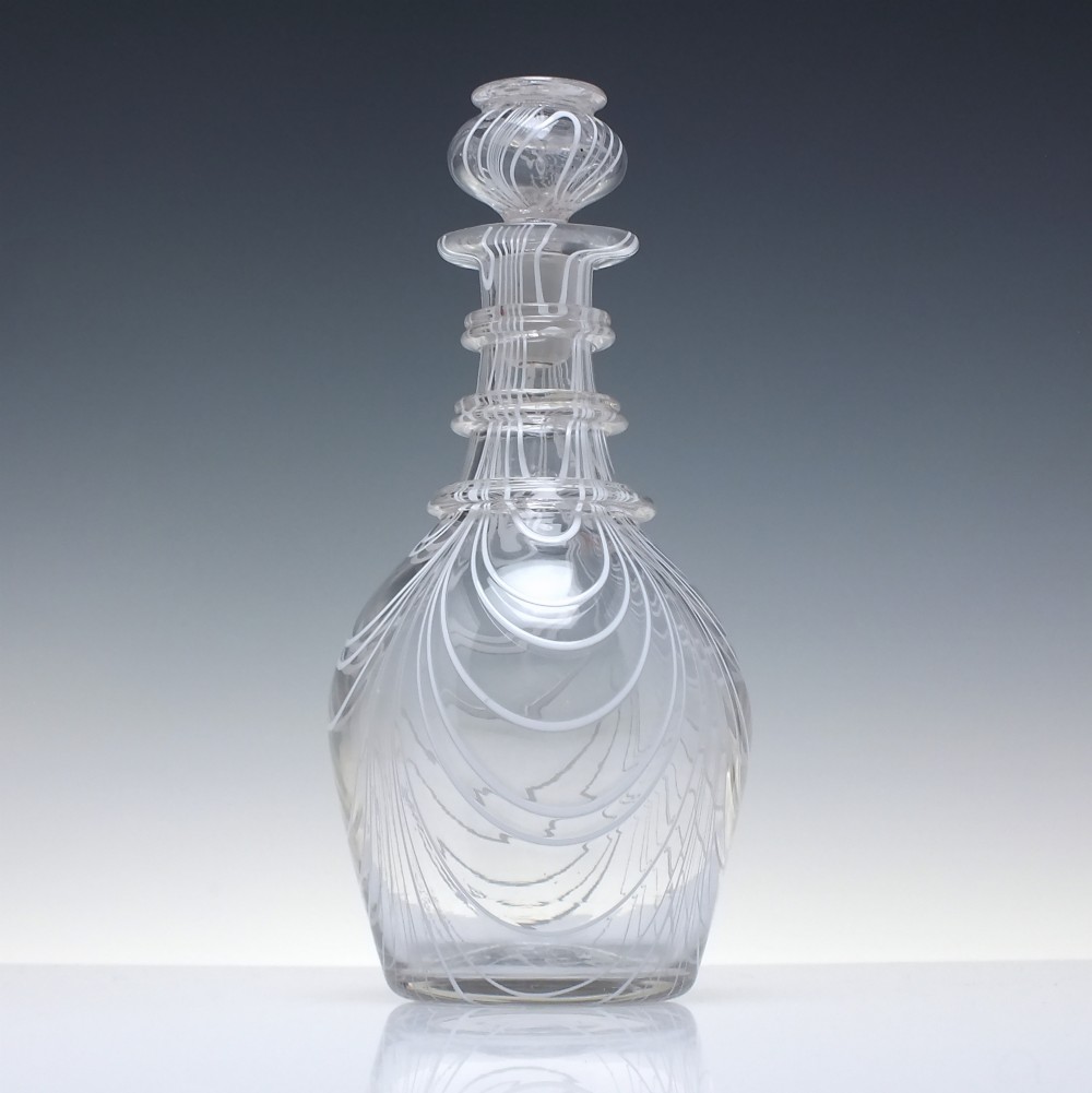 A clear lead glass Regency Prussian-shaped personal spirit decanter decorated with combed opaque white trailing and fitted with a matching glass stopper. View III