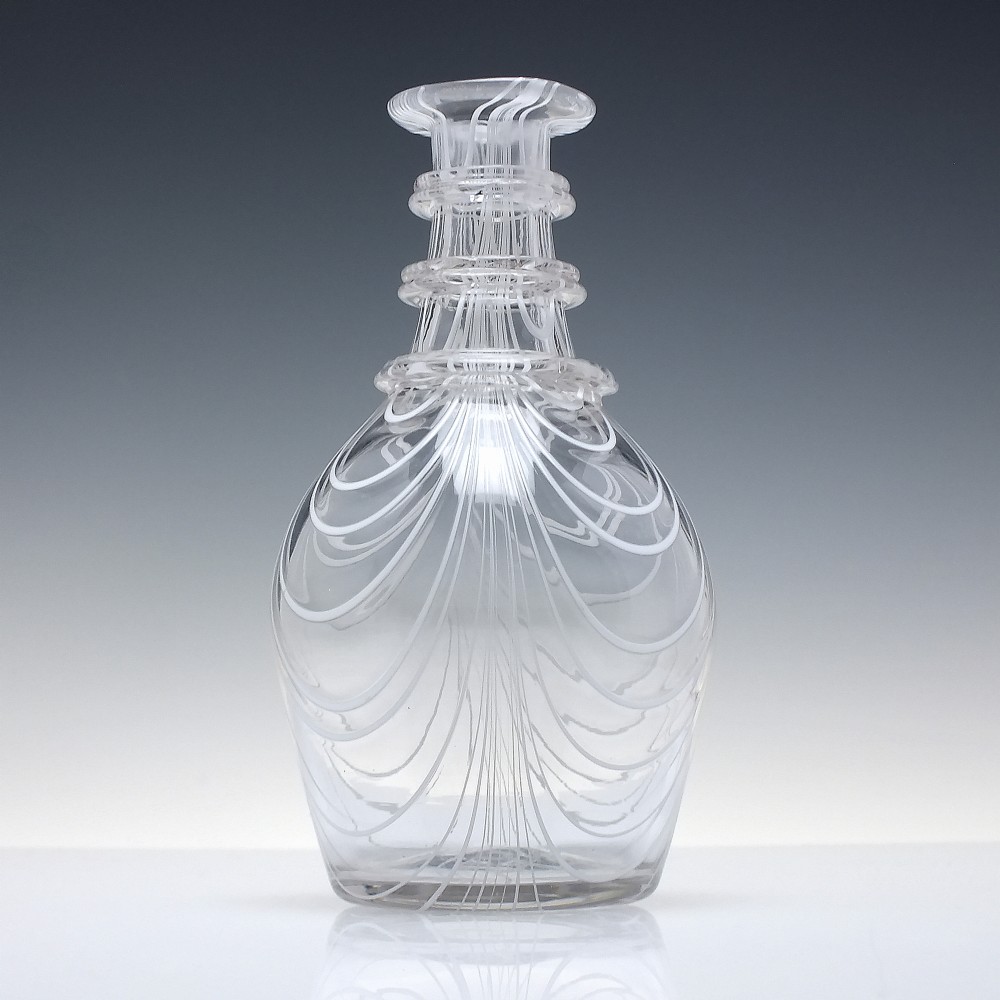 A clear lead glass Regency Prussian-shaped personal spirit decanter decorated with combed opaque white trailing and fitted with a matching glass stopper. View IV