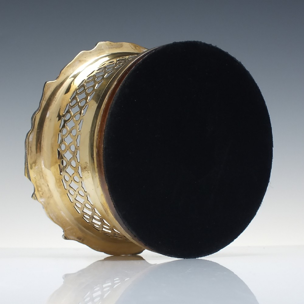 A Victorian gilded and silver plate champagne bottle coaster featuring a pierced lattice gallery, flared rim, and dark wood base. View V