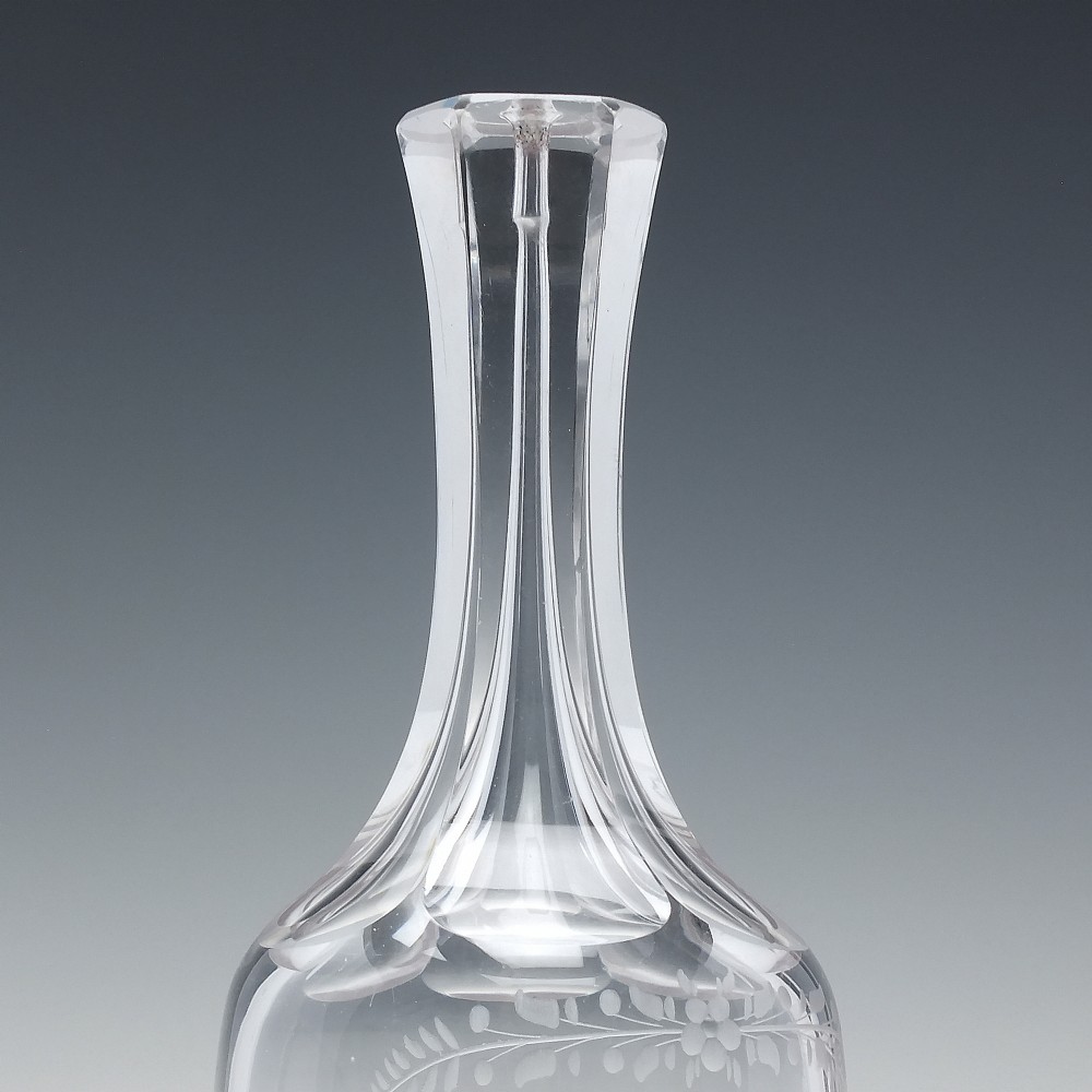 An 18th-century clear glass sugar loaf bitters bottle featuring a faceted slender neck, cut panel base, and wheel-engraved lettering spelling BITTERS surrounded by floral swags. View III