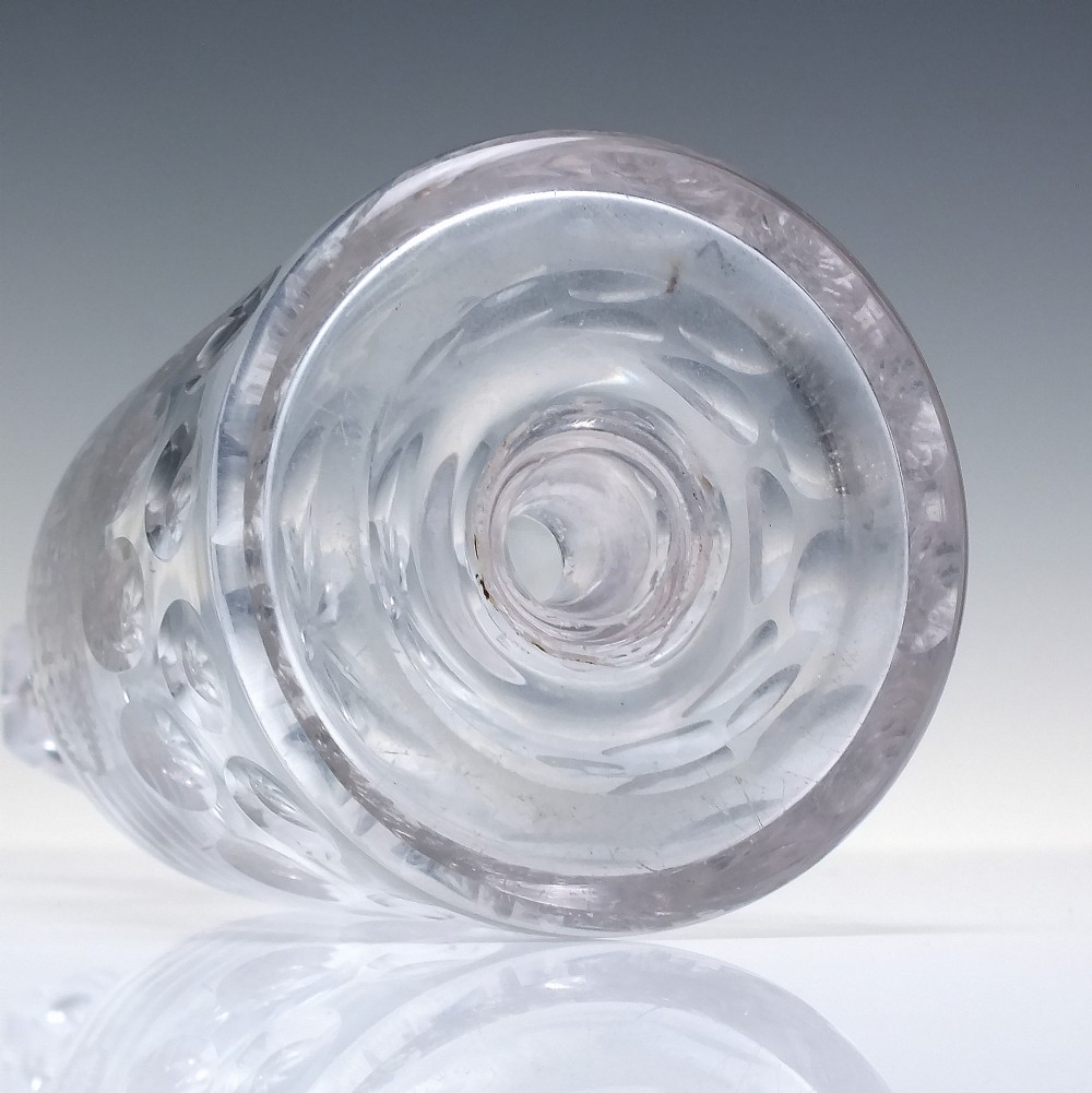 An 18th-century clear glass sugar loaf bitters bottle featuring a faceted slender neck, cut panel base, and wheel-engraved lettering spelling BITTERS surrounded by floral swags. View VII