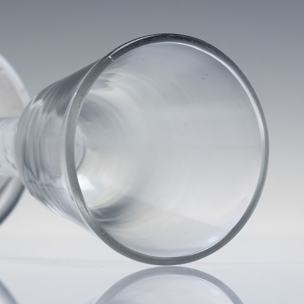 An 18th-century clear glass wine glass featuring an internal white opaque twist stem and a thickened firing foot base. View V