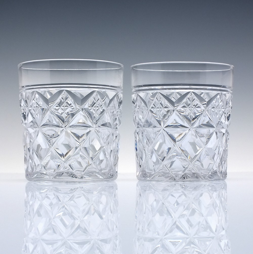 A pair of clear cut-crystal whisky tumblers featuring a deep diamond geometric pattern and smooth polished rims. View II