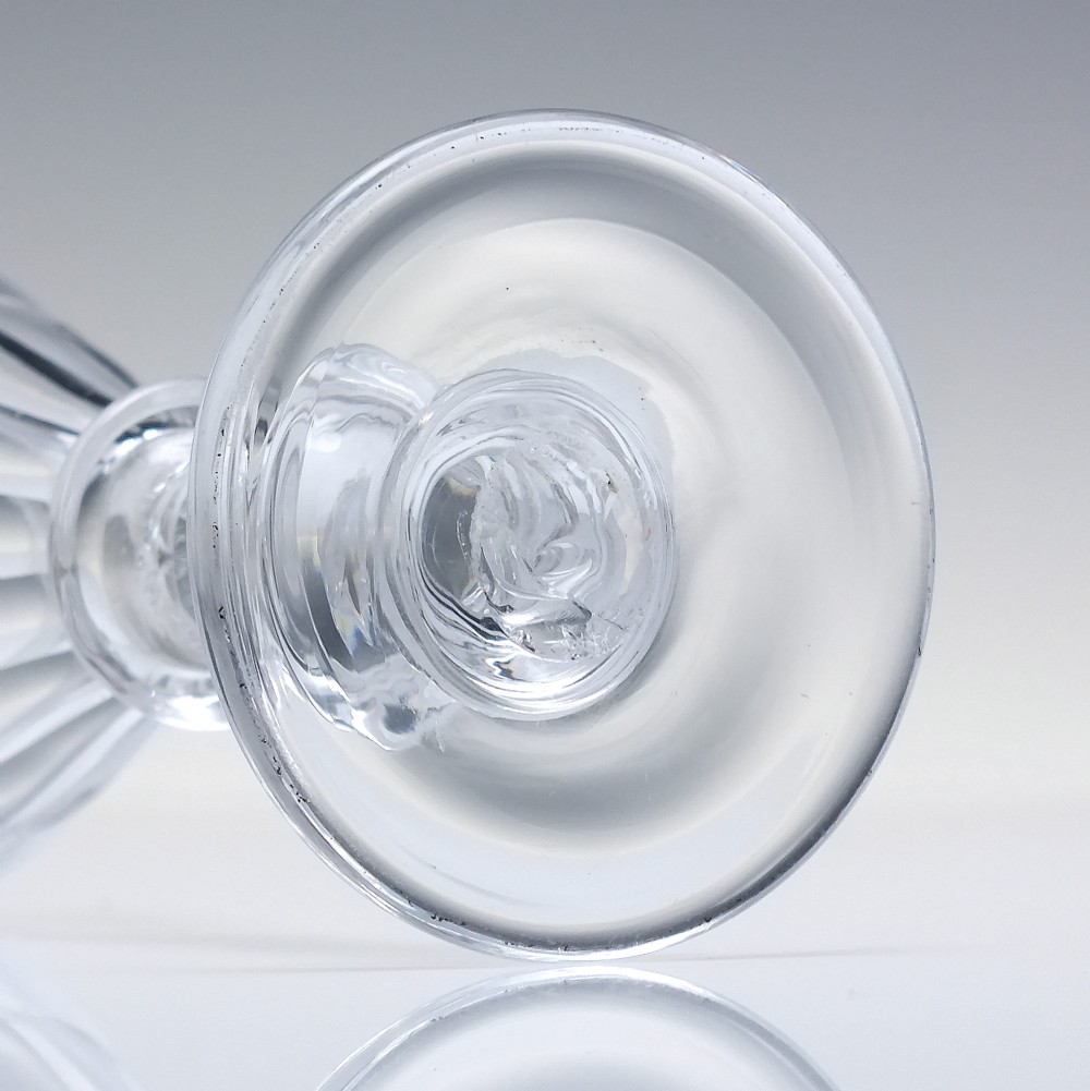 A pair of clear cut-glass Georgian dram glasses featuring conical bowls with vertical flutes and knopped stems on circular footed bases. View V
