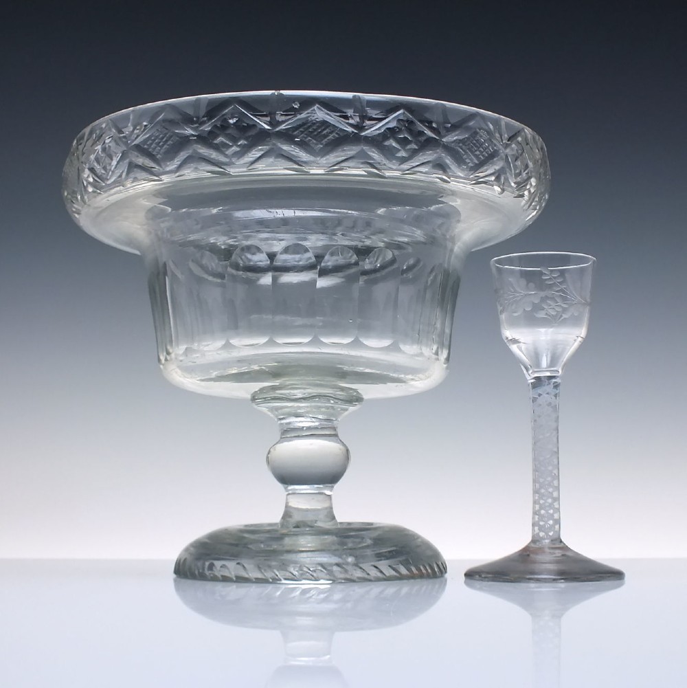 A clear Georgian cut glass standing bowl featuring a wide diamond-cut rim, fluted basin, knopped stem, and circular foot. View II