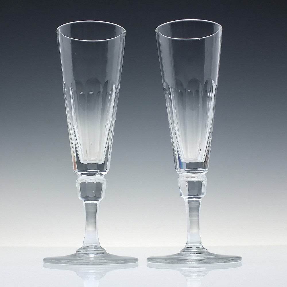 A set of six Victorian clear cut glass champagne flutes arranged in a row, featuring tall conical bowls with basal panel cutting and faceted stems. View II