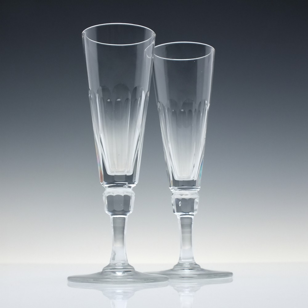 A set of six Victorian clear cut glass champagne flutes arranged in a row, featuring tall conical bowls with basal panel cutting and faceted stems. View III