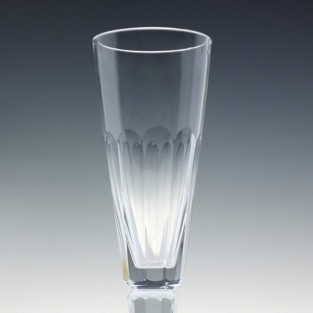 A set of six Victorian clear cut glass champagne flutes arranged in a row, featuring tall conical bowls with basal panel cutting and faceted stems. View IV