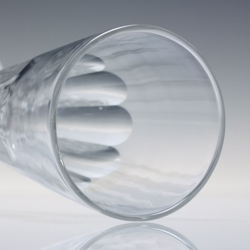 A set of six Victorian clear cut glass champagne flutes arranged in a row, featuring tall conical bowls with basal panel cutting and faceted stems. View V