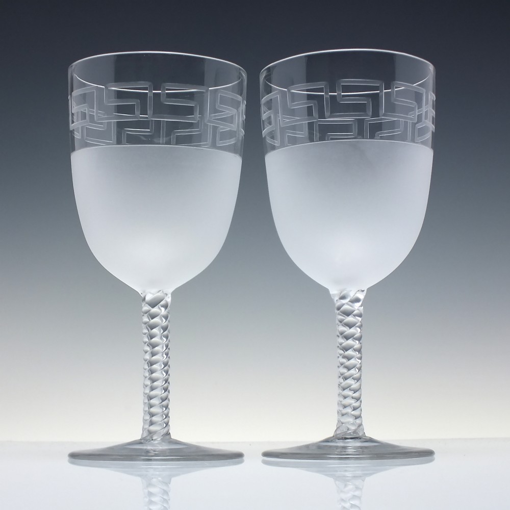A pair of clear and frosted Edwardian glass wine goblets featuring a Greek key engraved border and spiral twisted stems. View II