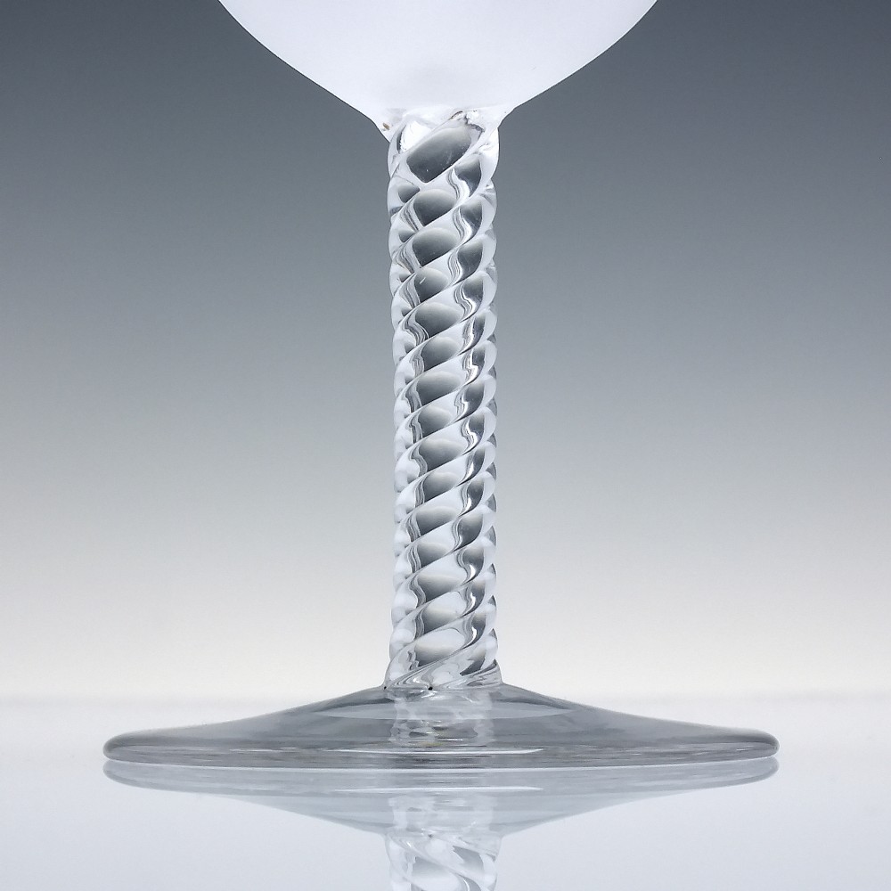 A pair of clear and frosted Edwardian glass wine goblets featuring a Greek key engraved border and spiral twisted stems. View IV