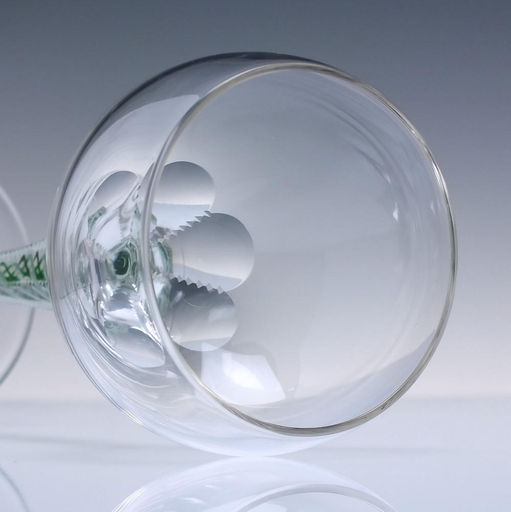 A pair of clear glass wine goblets featuring round bowls and tall stems decorated with internal green and white opaque twists. View VI