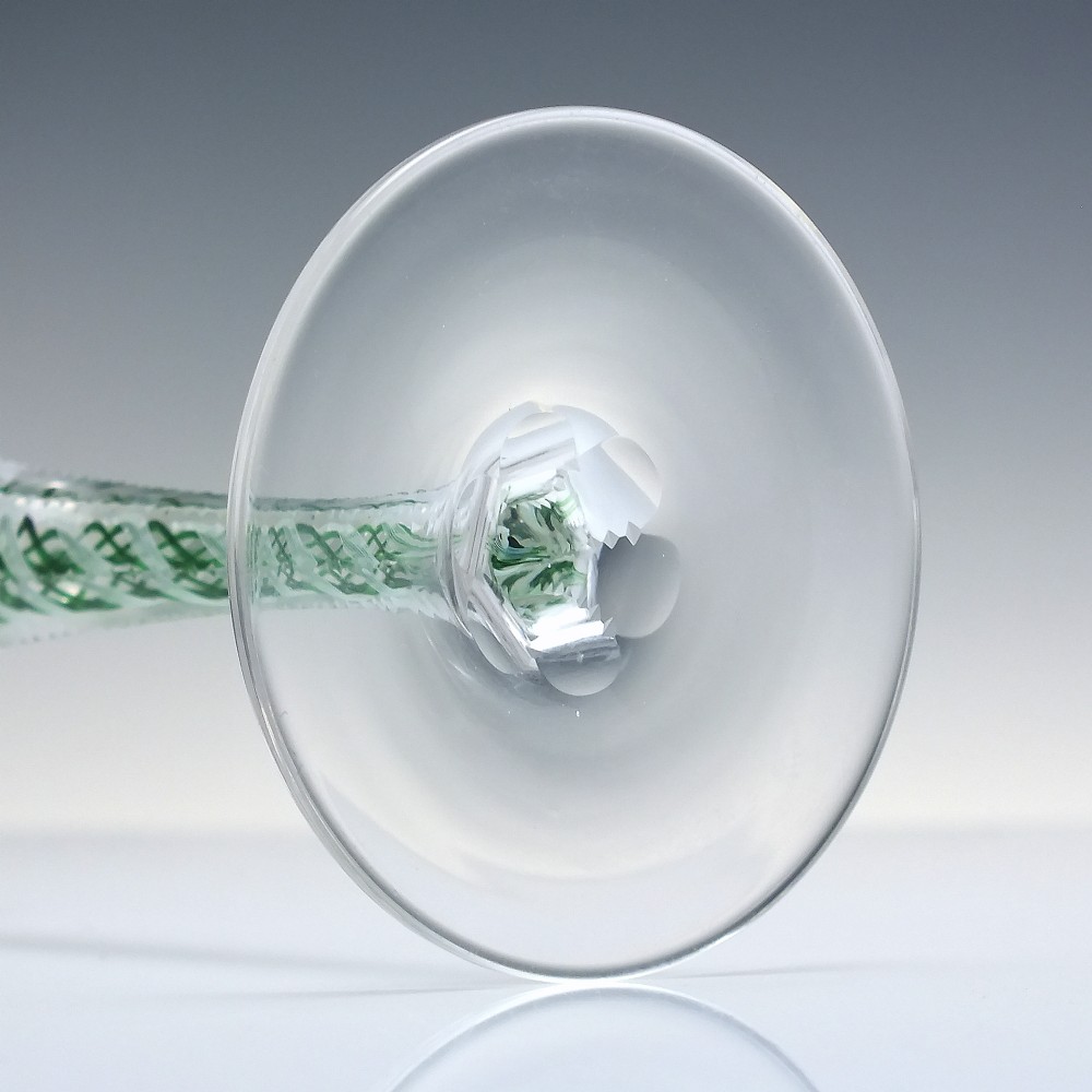 A pair of clear glass wine goblets featuring round bowls and tall stems decorated with internal green and white opaque twists. View VII