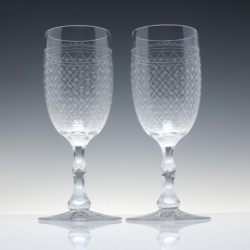 A pair of clear glass Victorian wine goblets featuring star and diamond pattern engravings with faceted stems. View II