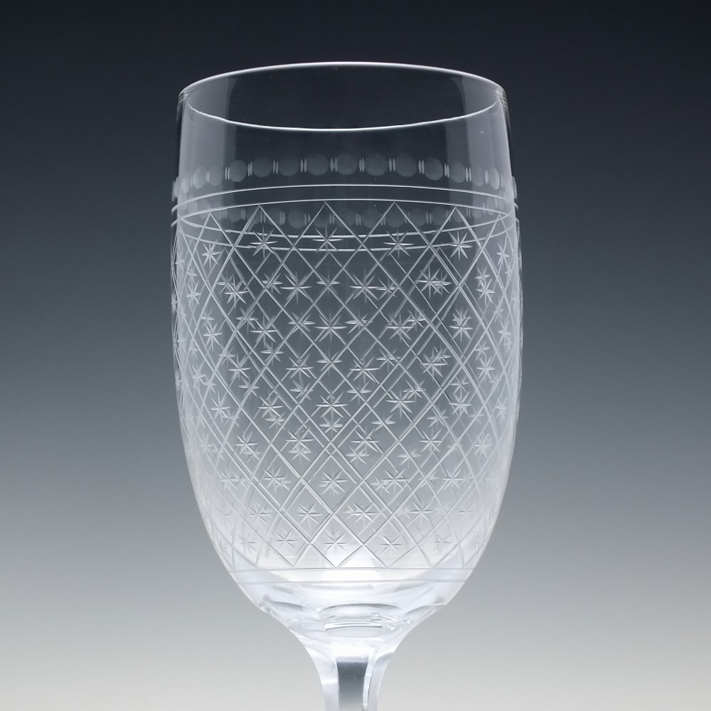 A pair of clear glass Victorian wine goblets featuring star and diamond pattern engravings with faceted stems. View IV